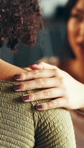 Friends, women and hands on shoulder for support with breakup, depression and relationship advice. Empathy, compassion and person with comfort for stress, overthinking and mental health in apartment